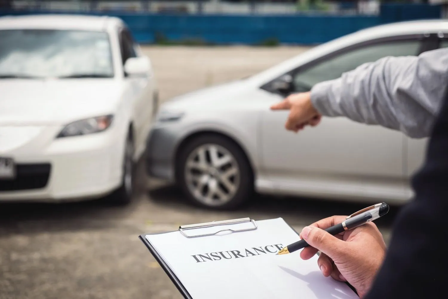 Driver filling out a car insurance form after a bump