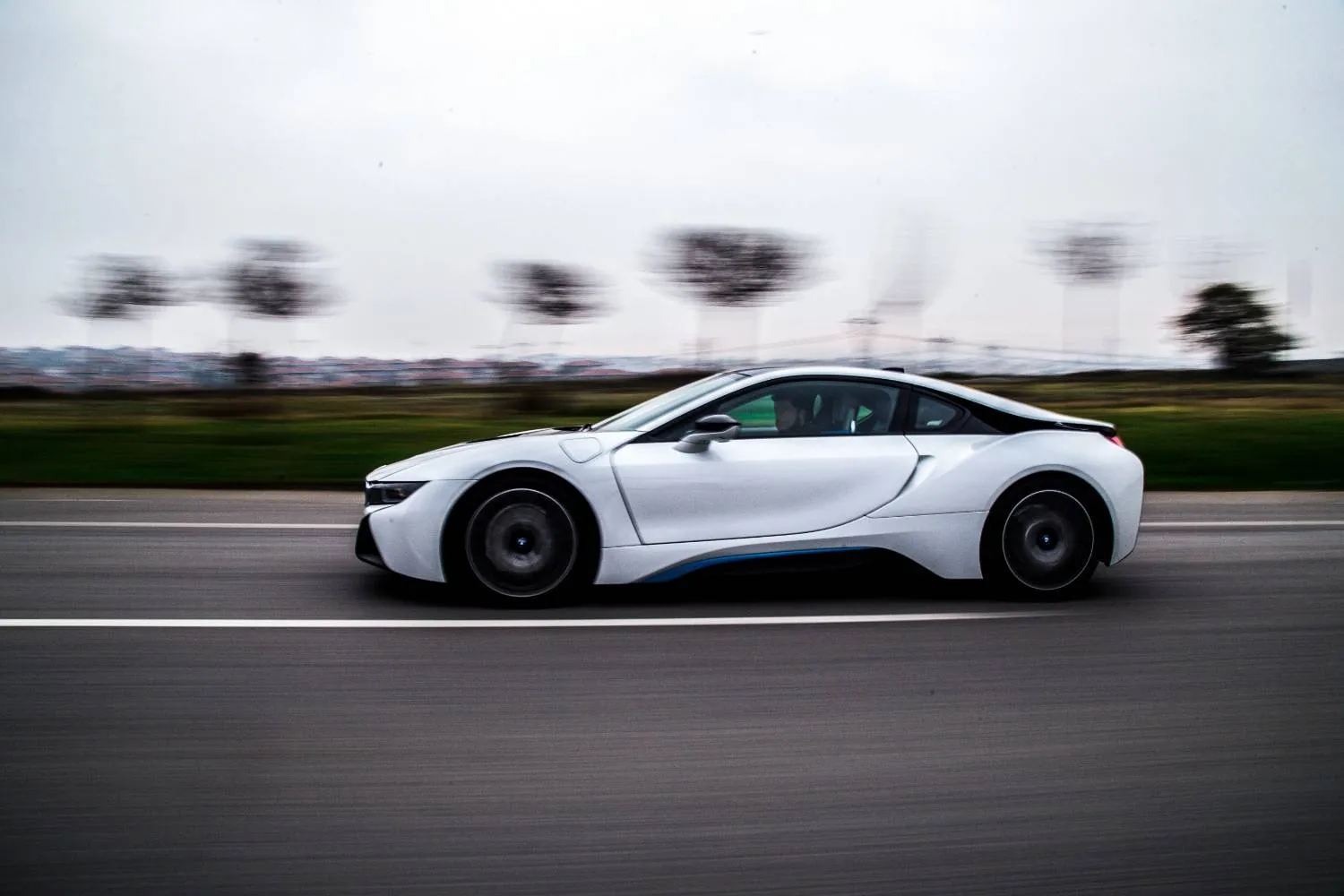 White car moving along an open road